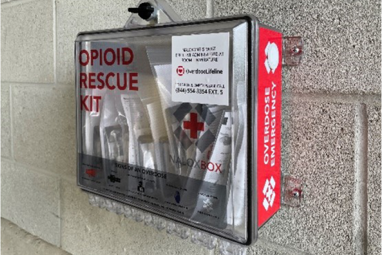 A photo of a Naloxbox in the parking garage on the wall by the Campus Center.