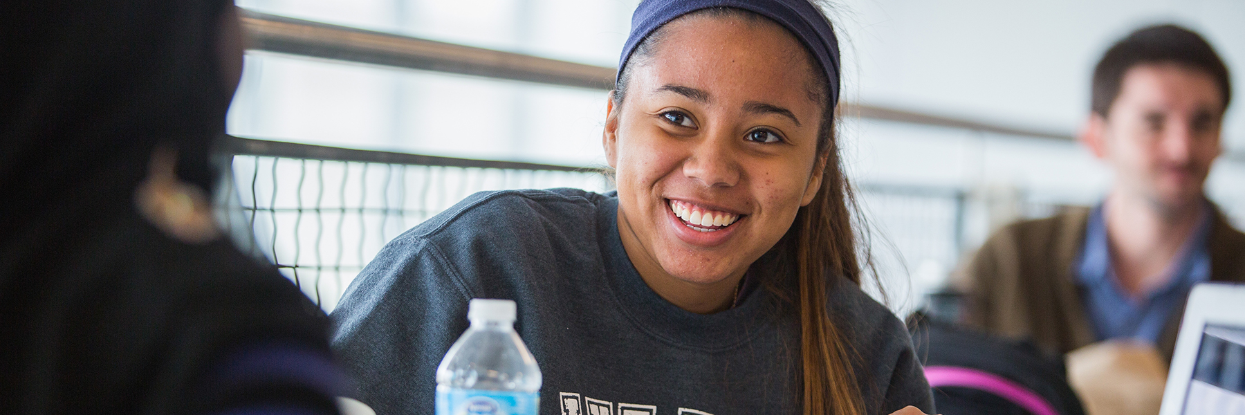 Student in the campus center with a smile on their face.