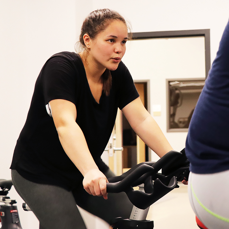 Woman rides an indoor bicycle.