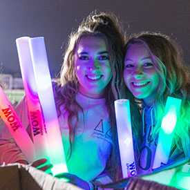 Two students pose with glow sticks at the light up the night event.