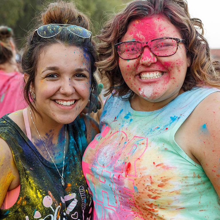 Two students smile at the camera