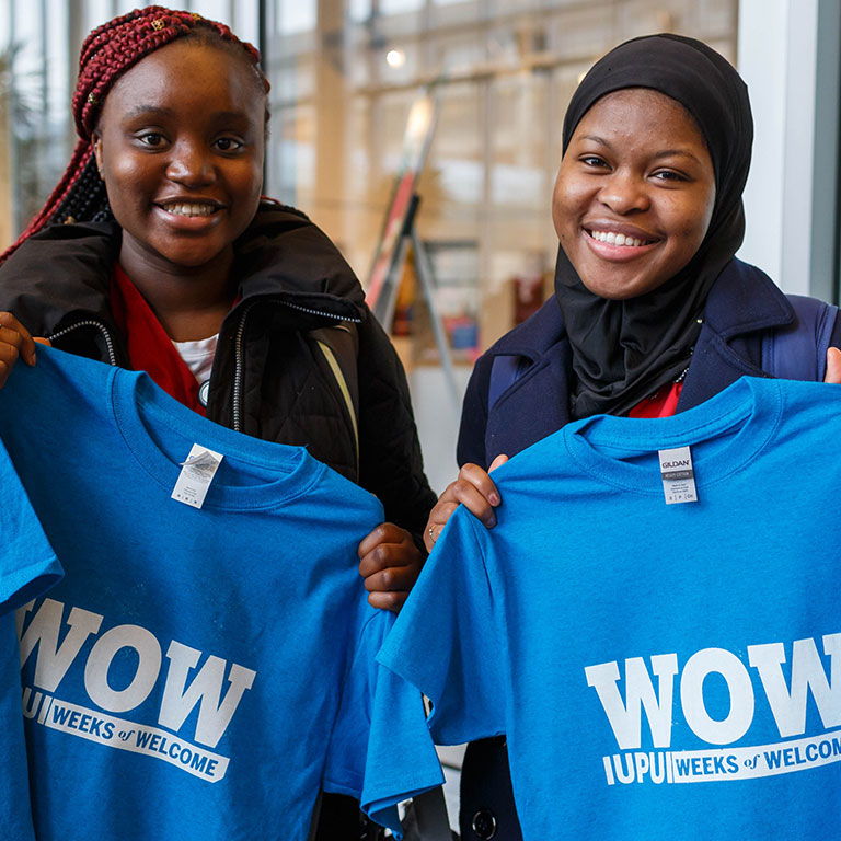 Two students holding up their custom made WOW shirts.