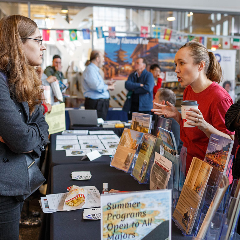 A student visits an information table at the Study Abroad Fair.